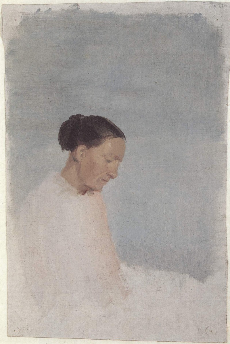 Frau vor der blauen Wand eines Raumes im Bett sitzend